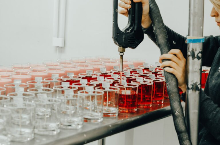 produção artesanal de velas aromáticas no ateliê Candela Aromas com processo de enchimento manual